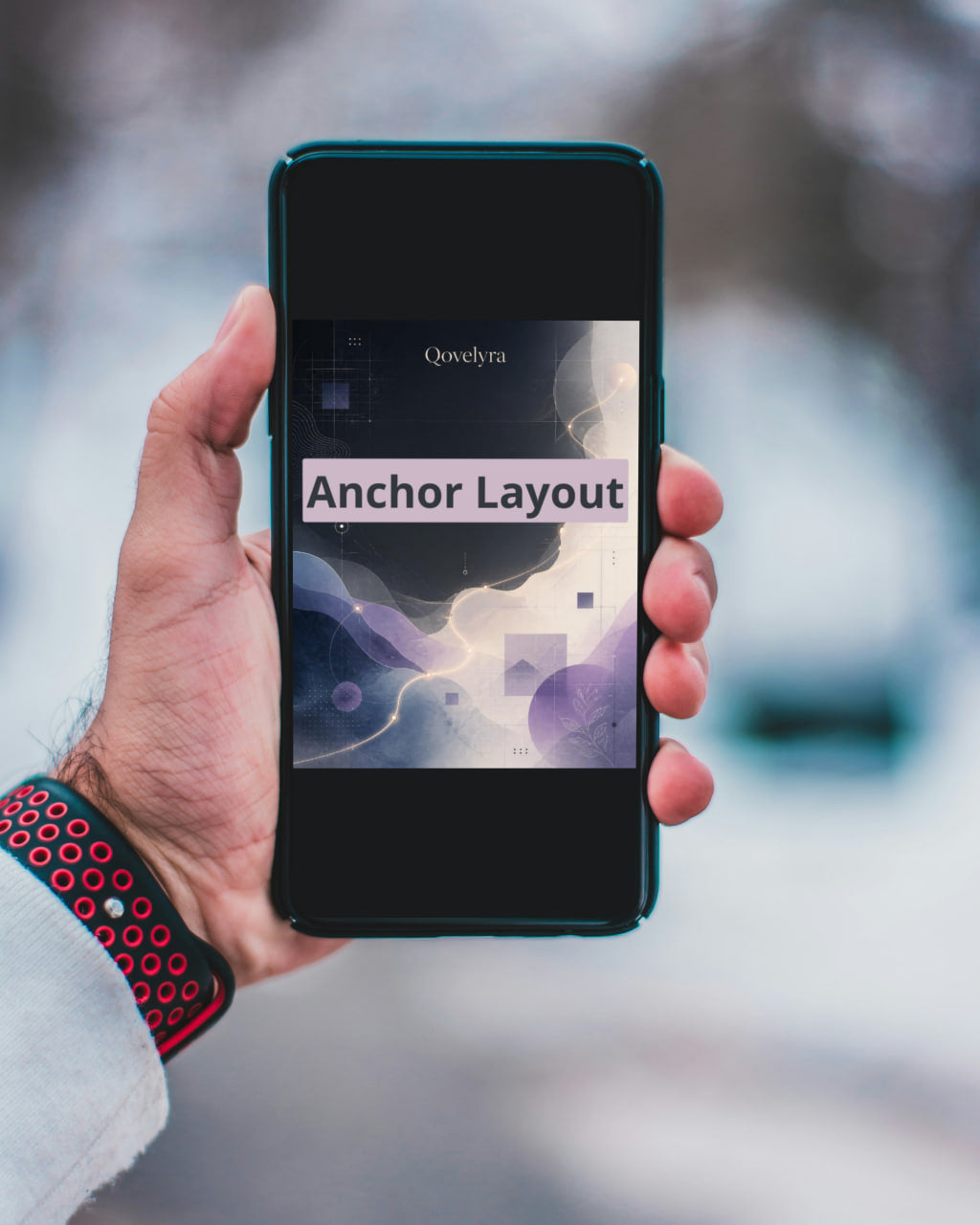 A hand holds a smartphone displaying a presentation slide titled 'Anchor Layout' by Qweytra, with a blurred outdoor background.