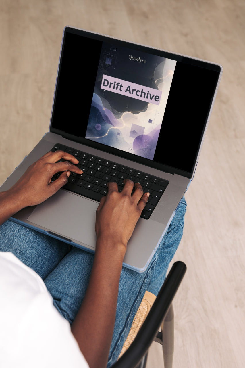 A person typing on a silver laptop with blue jeans, shown from an overhead angle in a bright indoor setting. The laptop screen displays a digital cover titled 'Drift Archive' with the brand name 'Odeyo' visible at the top.