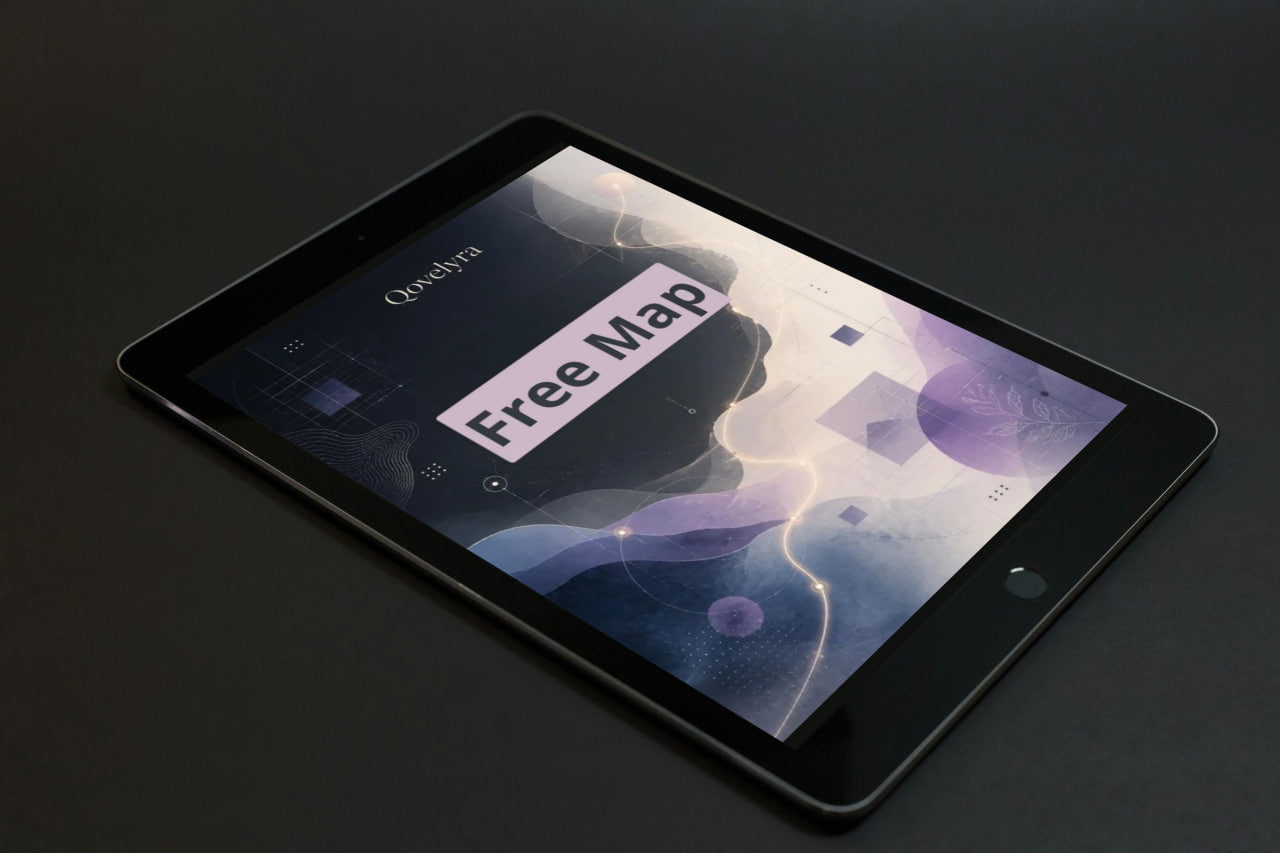 A black tablet device shown at an angle on a dark surface, with its screen on displaying the word 'Qorelya' and a large 'Free Map' banner over an abstract purple and blue graphic.
